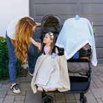Child in stroller with blanket secured using whimSi clips, best baby registry product 2026 | Stroller blanket clip in action, keeps baby warm and comfortable during walks and outings