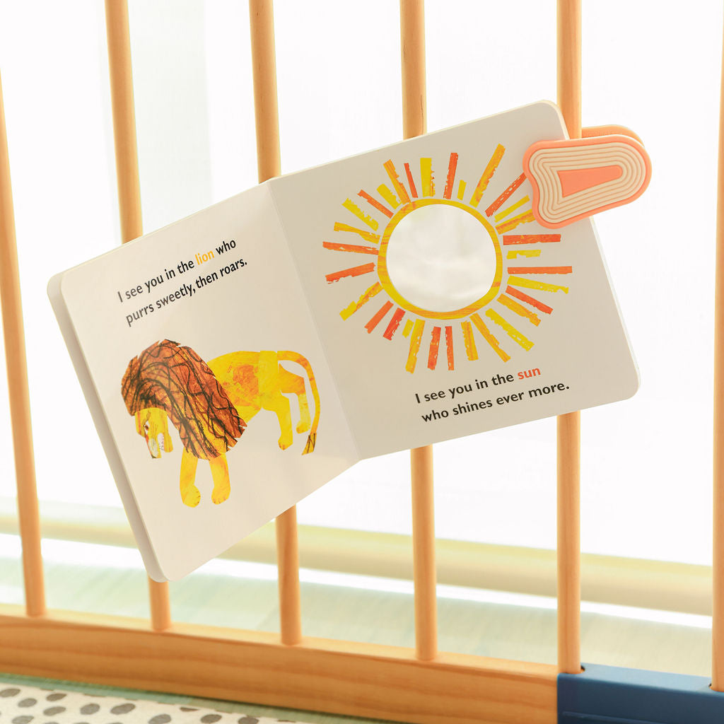 Fire whimSi clip holding board book to crib rail in nursery