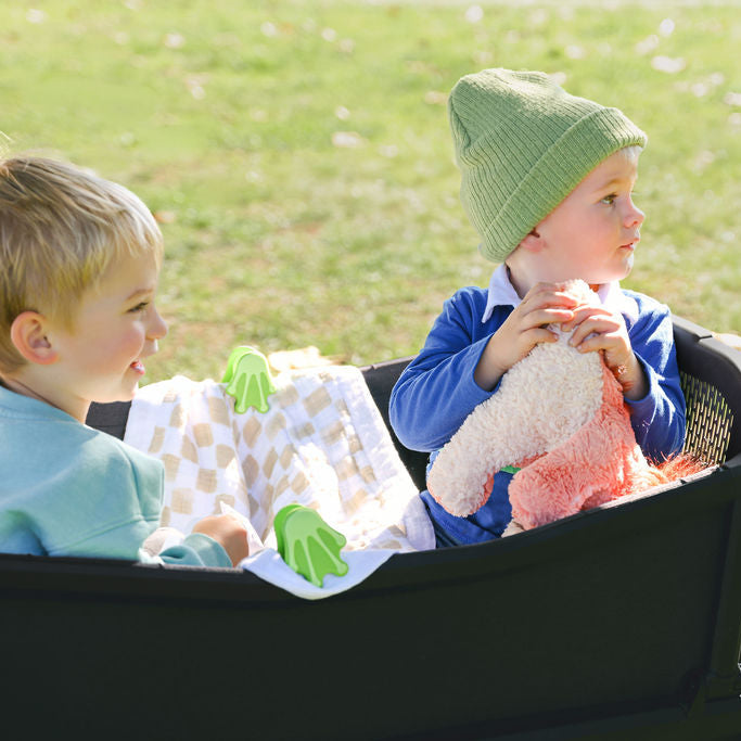 Two toddlers in wagon with Froggy Feet whimSi clips holding blanket