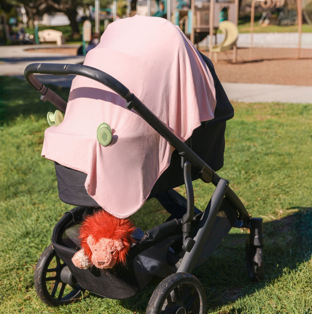 Pinch-free silicone stroller clip holding a blanket on a baby stroller, top baby registry pick 2026 | Best stroller blanket clip for keeping baby warm and cozy, prevents blankets from falling or dragging