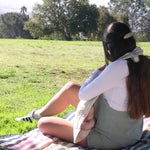 mom nursing at park using whimSi clips to hold a nursing cover conveniently in place