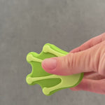 Hand squeezing froggy foot whimSi clip design.  opening and closing soft silicone clip with innovative silicone spring