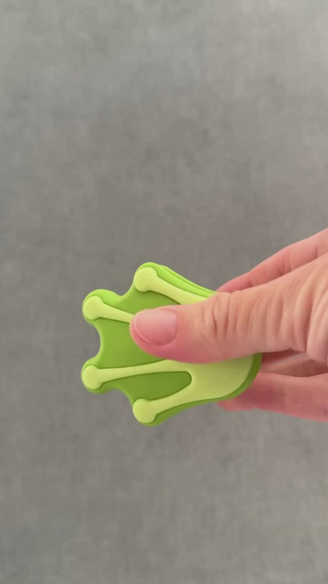 Hand squeezing froggy foot whimSi clip design.  opening and closing soft silicone clip with innovative silicone spring